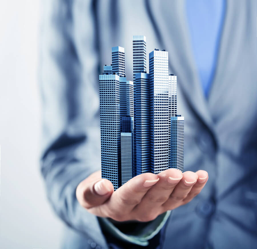 Man Holding miniature skyscrapers on his palm