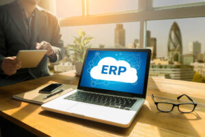 ERP cloud image on a laptop screen, desk, man, glasses, London on the background