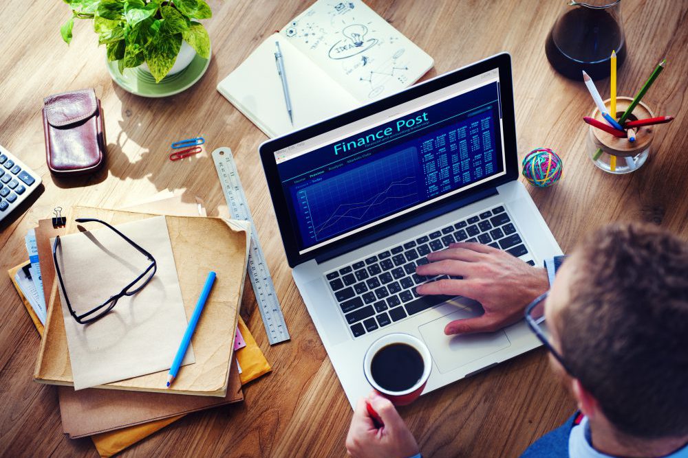 Working desk with laptop and financial chart on the screen