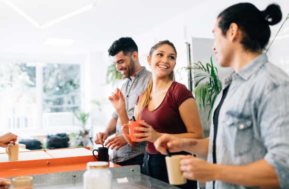 Office setting people laugh drink coffee